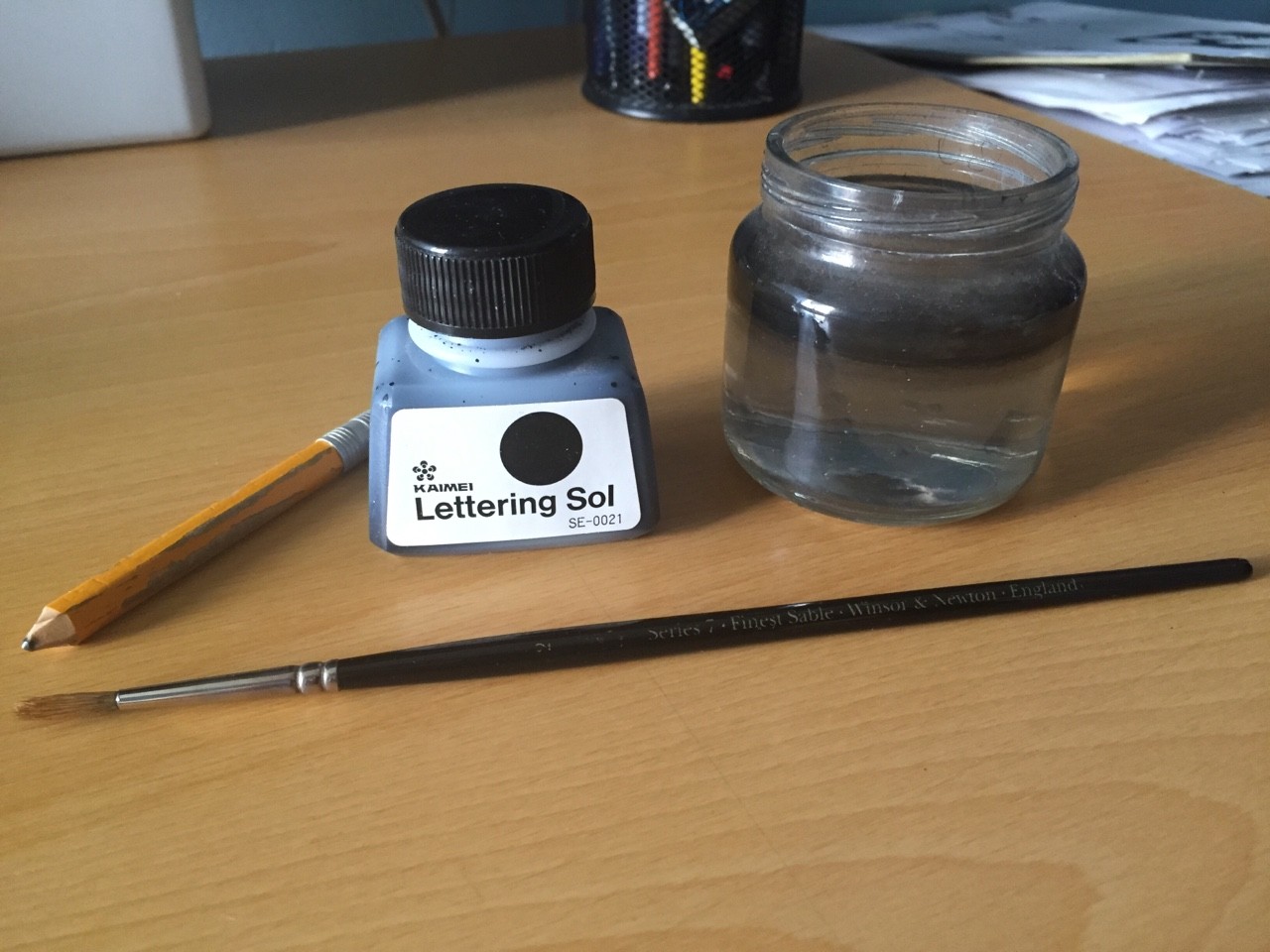 This are my main tools: My good old 3 year old pencil, a bottle of water, a #2 Series 7 Winsor and Newton brush, and drawing ink. The one I use is Kaimei Lettering Sol. Very nice ink and super water resistant. 