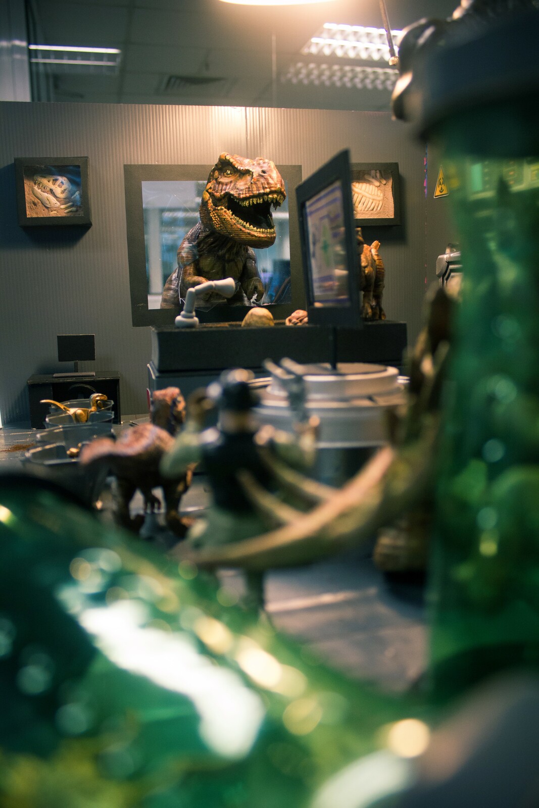 
The T-rex cracked the window and peeked inside!

The green cylinders were soda bottles.
