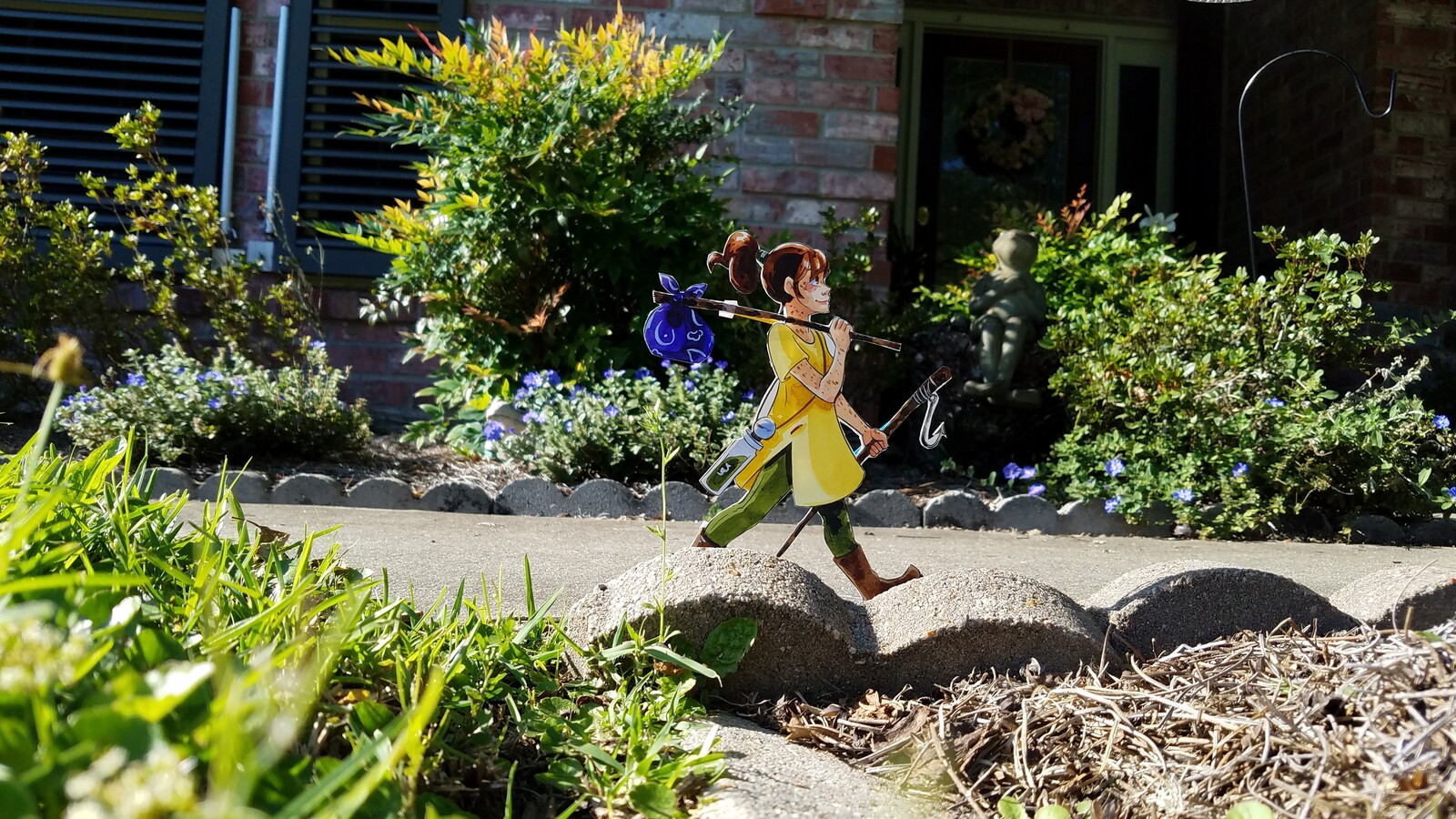 Cut paper character posed in a real world environment create an augmented reality perfect for suburban fantasy.