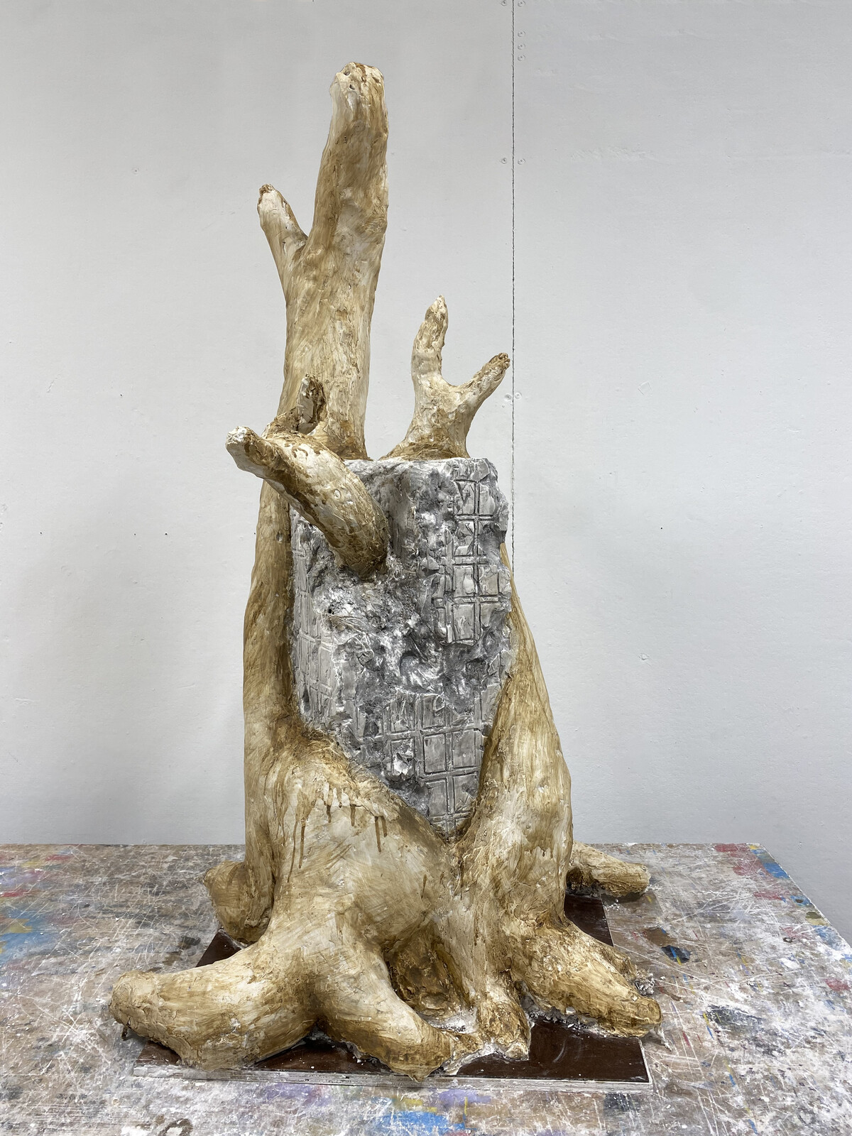 Plaster piece depicting a building being overtaken by a large tree.  Underlying skeleton made from wood and chicken wire