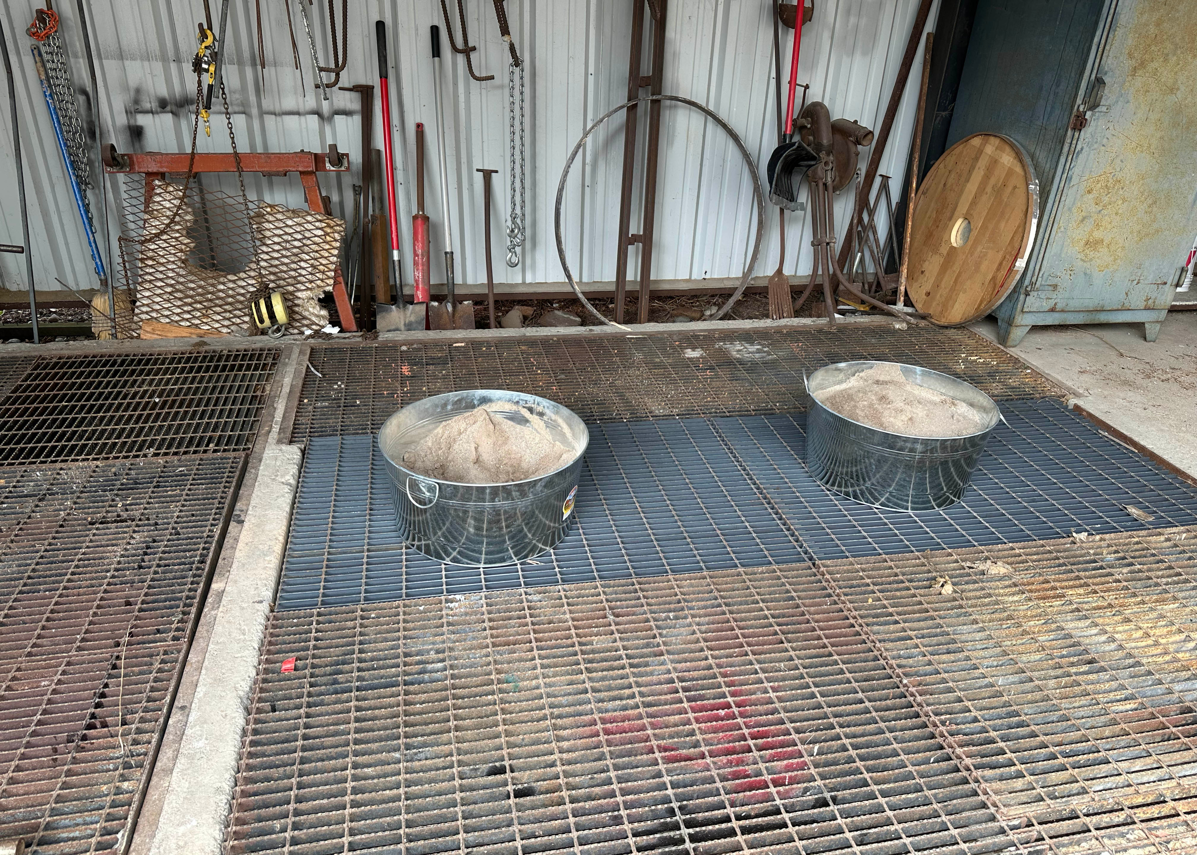 Buckets of sand. The molds are partially buried in the sand when metal is being poured. 