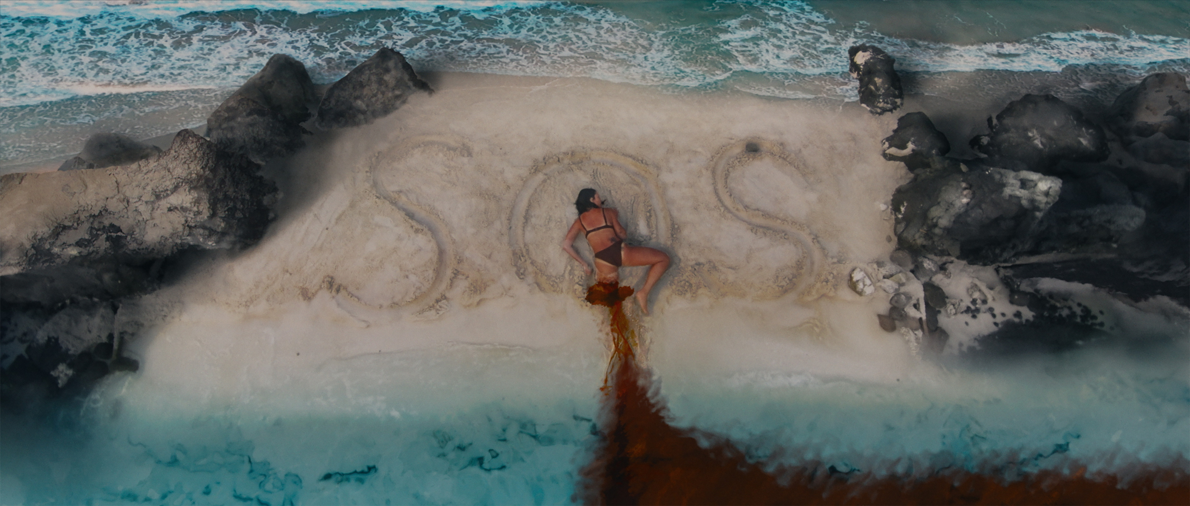 Dying  on the beach SOS message - film still.