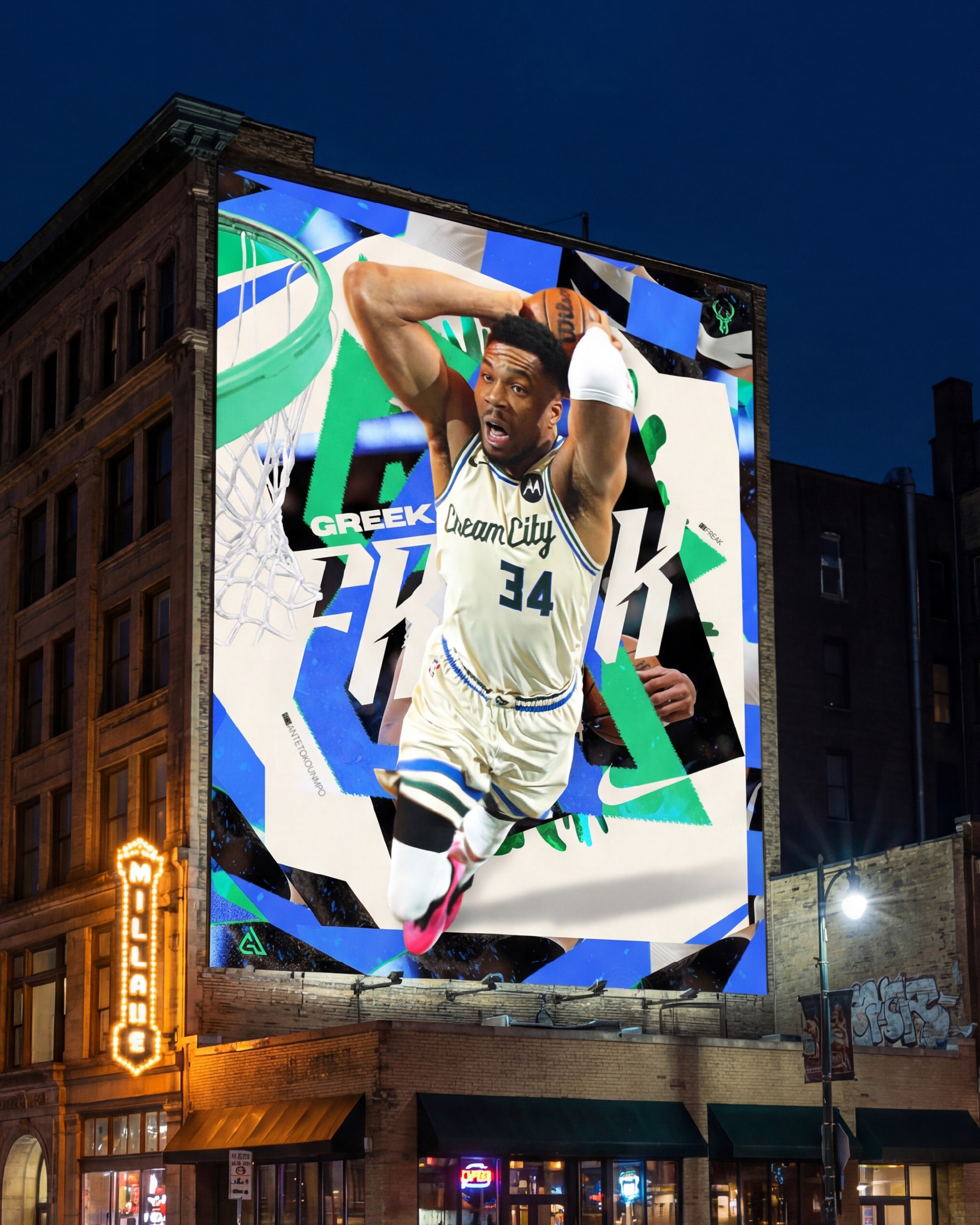 The campaign mounted on a Milwaukee building at night. The cream and electric blue palette glowing against the dark urban sky is exactly what this design was built for